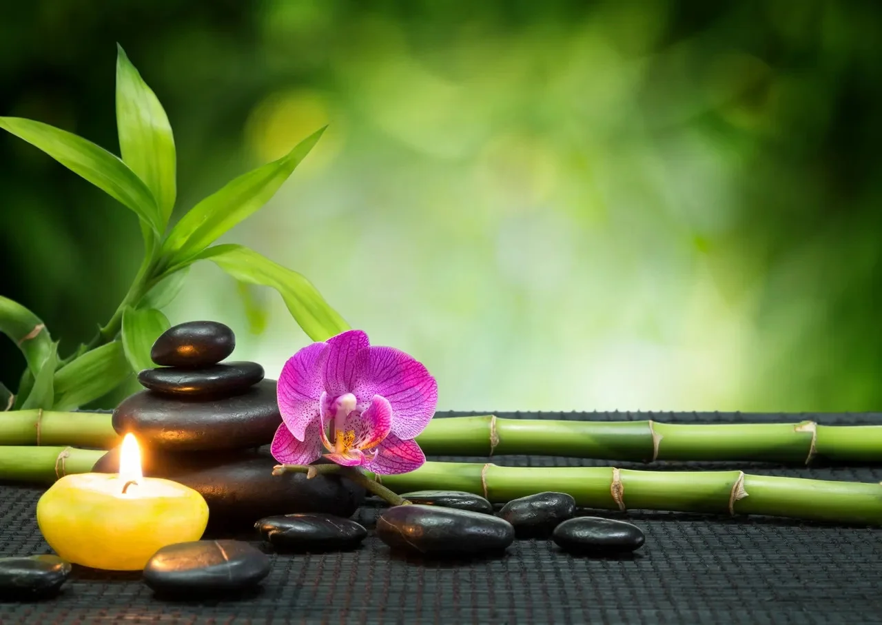 Stacked smooth stones with eucalyptus on warm linen — calming spa setting